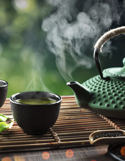 Japanese Tea - Hot Teapot And Teacups On Bamboo Mat